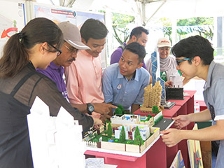 Md. Pilus (second left) talking to IUKL architecture students at the building model exhibition booth at the Student Village.